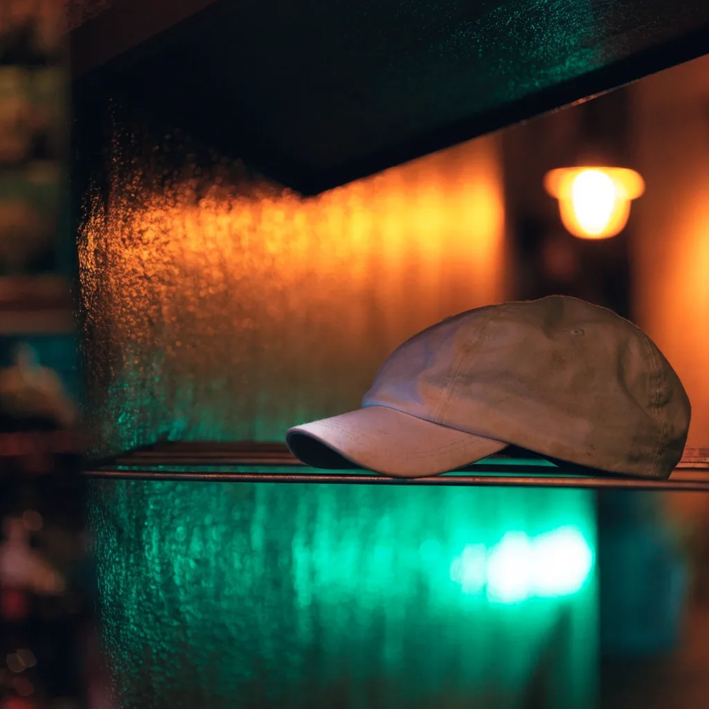 Coureur de nuit portant une casquette de running dans une rue mouillée