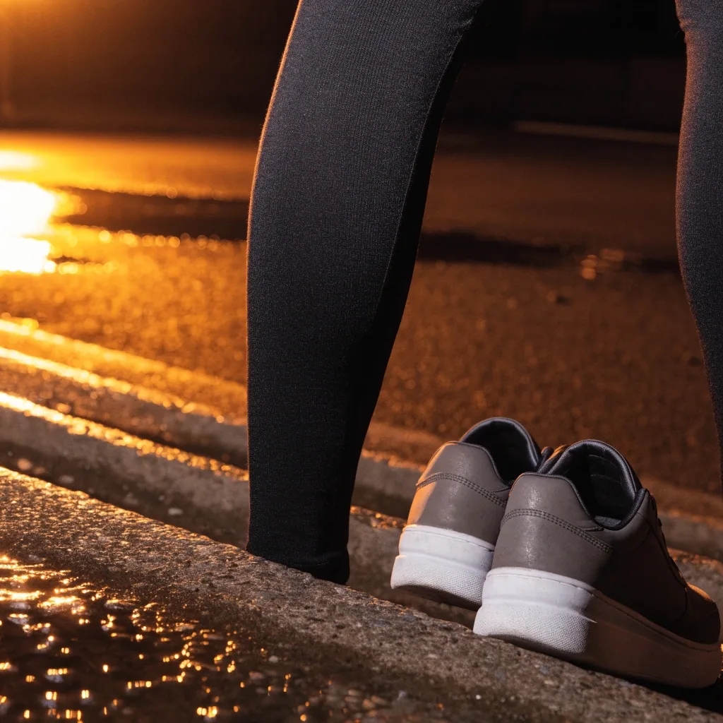 Legging de sport et chaussures de running posés sur l'asphalte mouillé la nuit